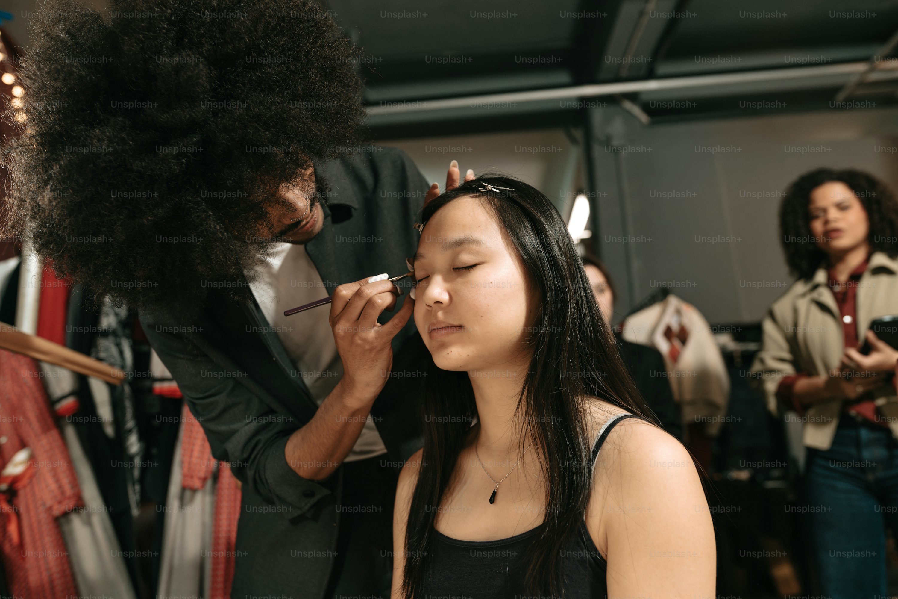 Makeup artist preparing a model backstage