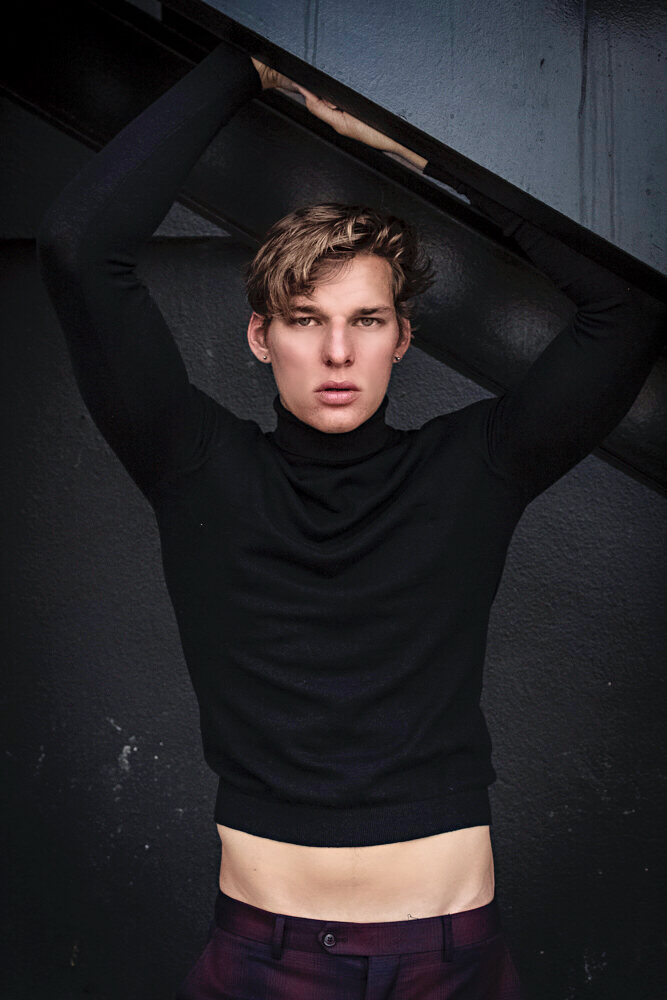 Model in a black turtleneck with dramatic directional lighting