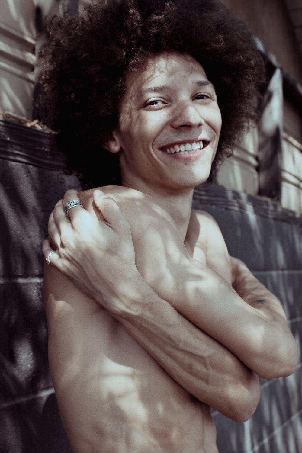 Warm-toned portrait of a smiling man with an afro