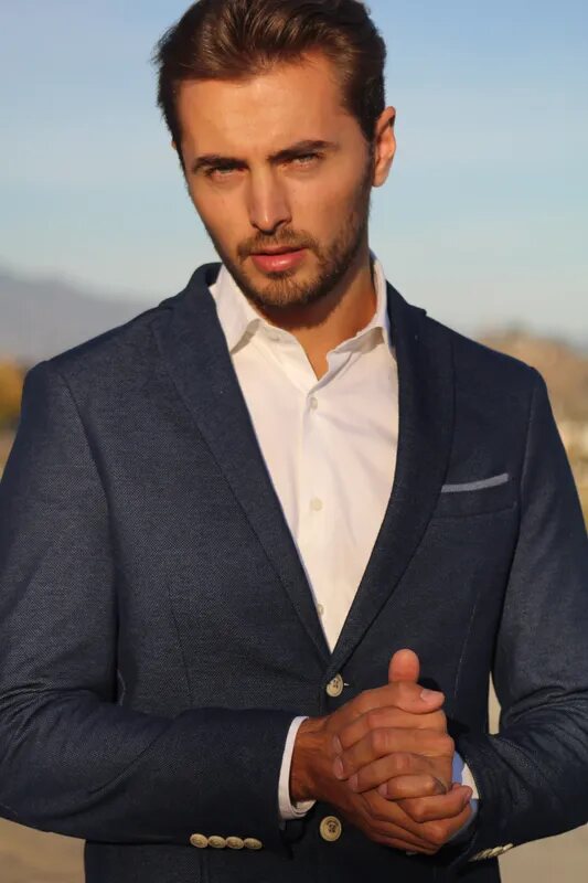 Man in a navy blazer and white shirt in soft golden-hour light