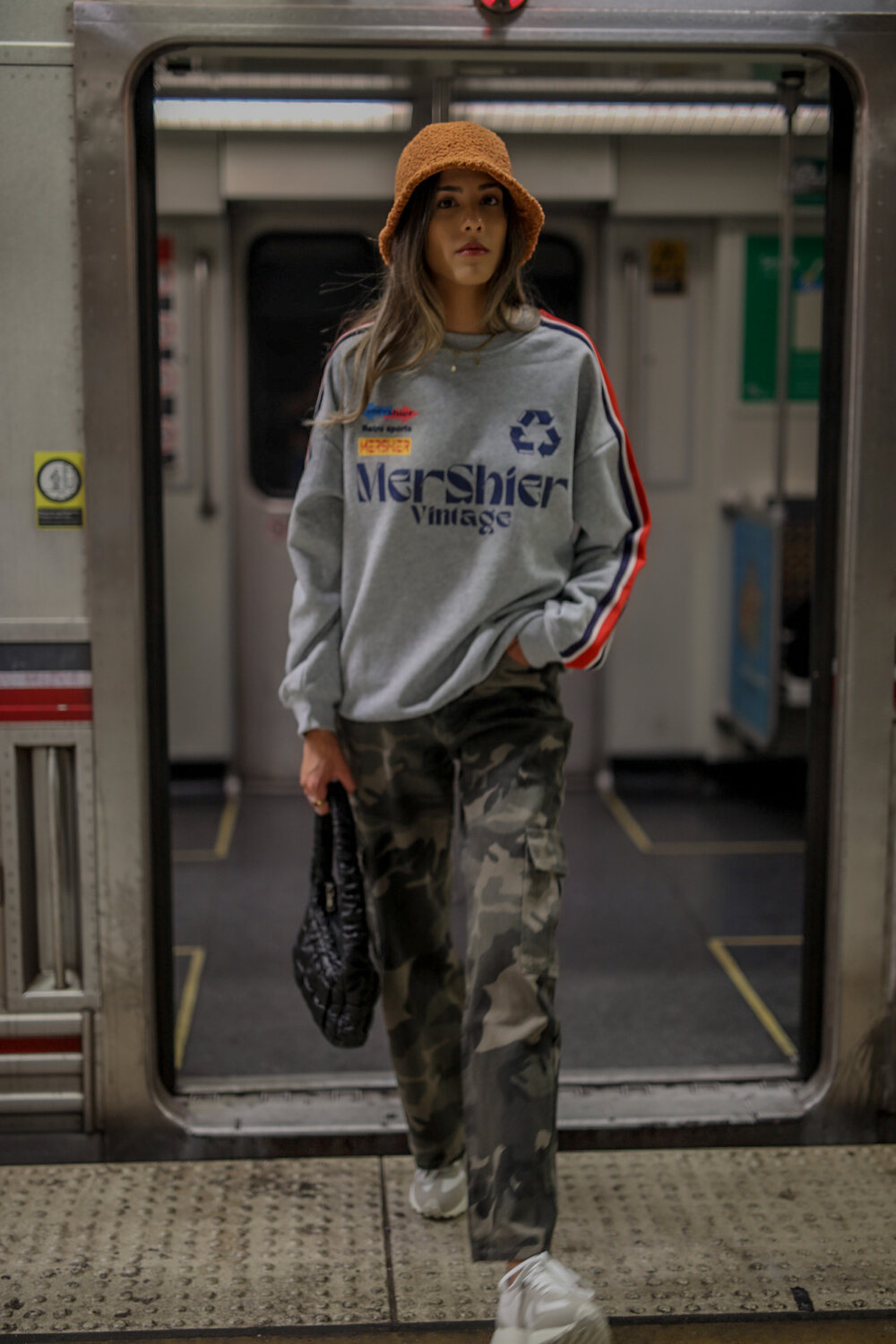 Model in vintage streetwear standing in a subway doorway
